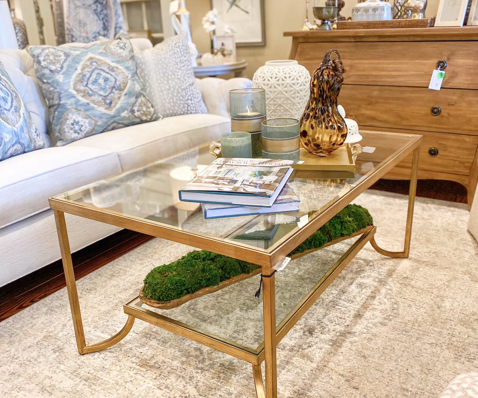 A glass coffee table with various southern-rustic pieces